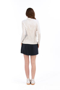 Woman wearing a White Textured Floral long-sleeve sun blocking top with a zipper, standing against a white background.