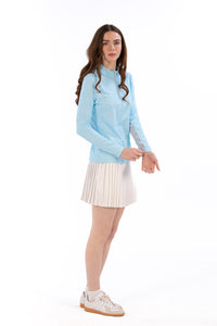 Woman wearing a Light Blue Geo long-sleeve sun blocking top with a zipper, standing against a white background.