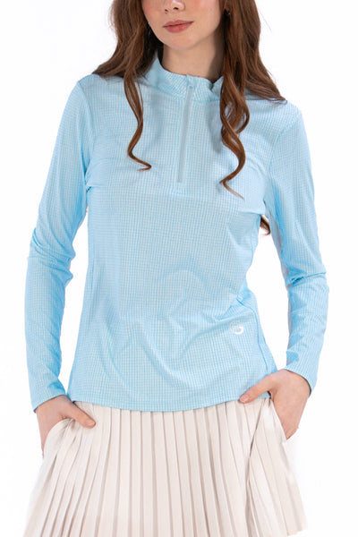 Woman wearing a Light Blue Geo long-sleeve sun blocking top with a zipper, standing against a white background.