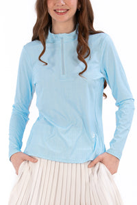Woman wearing a Light Blue Geo long-sleeve sun blocking top with a zipper, standing against a white background.