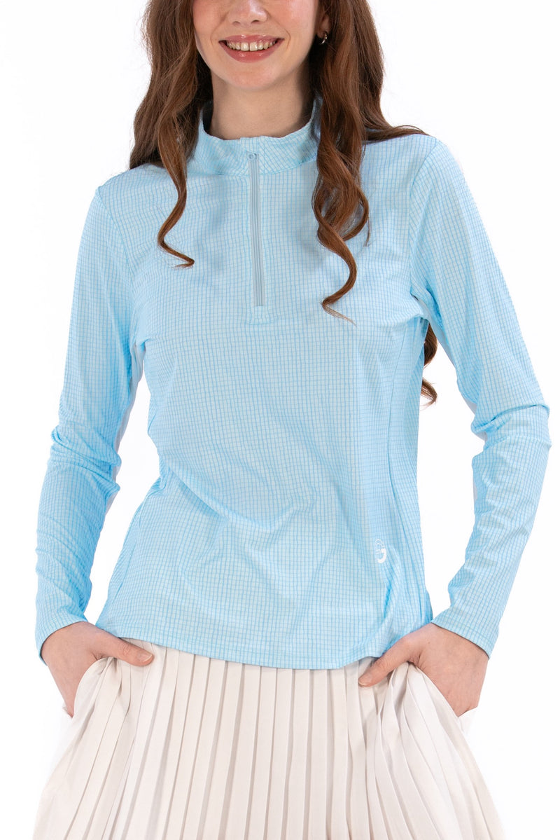 Woman wearing a Light Blue Geo long-sleeve sun blocking top with a zipper, standing against a white background.