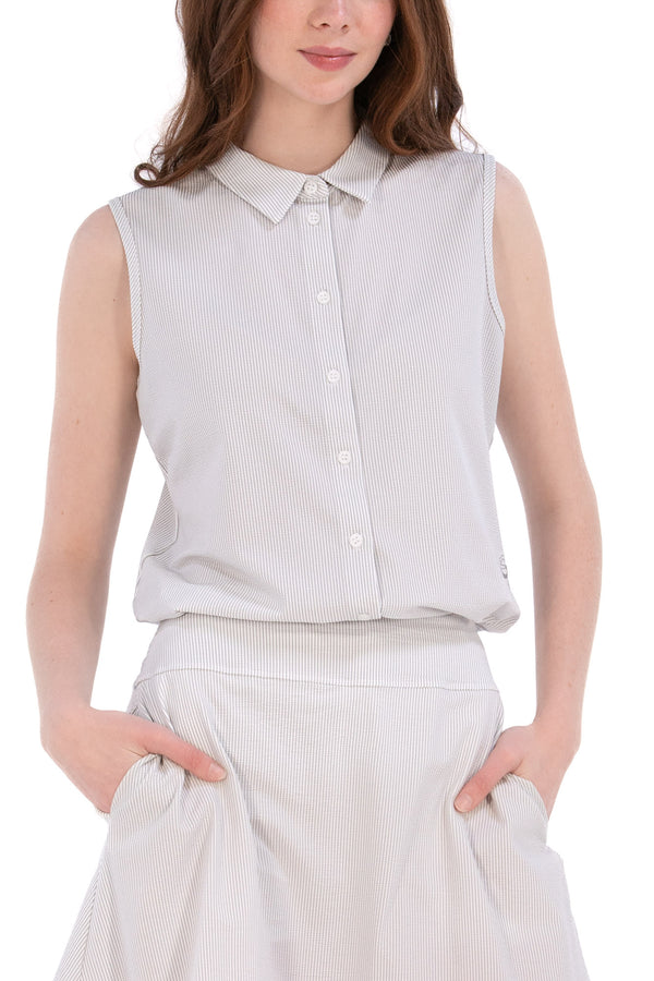 Woman wearing a sleeveless seersucker grey polo 