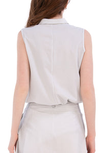 Woman wearing a sleeveless seersucker grey polo 