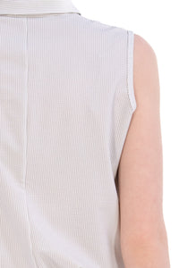 Woman wearing a sleeveless seersucker grey polo 
