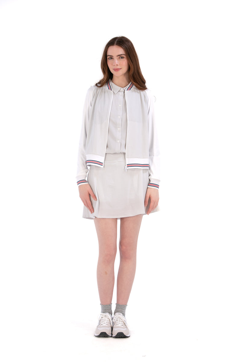 Woman wearing a Grey seersucker jacket with red accents on a white background