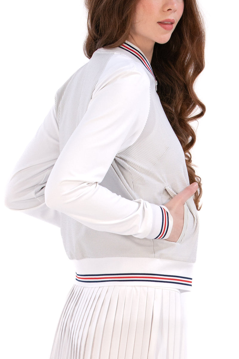 Woman wearing a Grey seersucker jacket with red accents on a white background