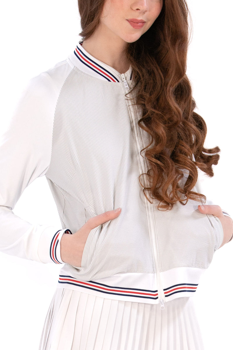 Woman wearing a Grey seersucker jacket with red accents on a white background