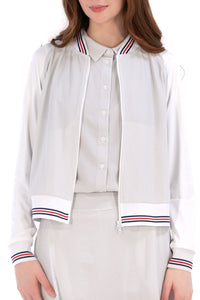 Woman wearing a Grey seersucker jacket with red accents on a white background