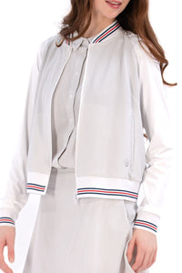 Woman wearing a Grey seersucker jacket with red accents on a white background