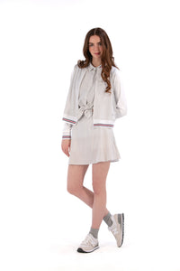 Woman wearing a Grey seersucker jacket with red accents on a white background