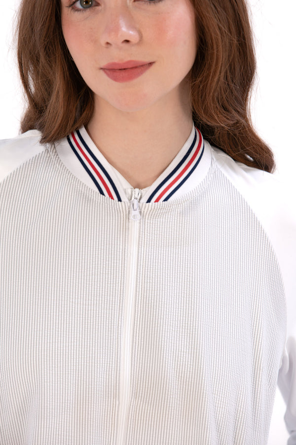 Woman wearing a Grey seersucker jacket with red accents on a white background