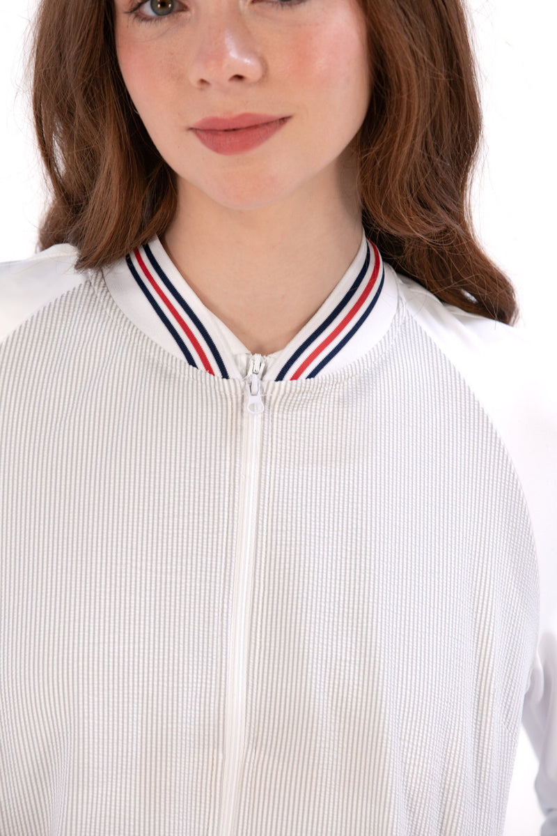 Woman wearing a Grey seersucker jacket with red accents on a white background