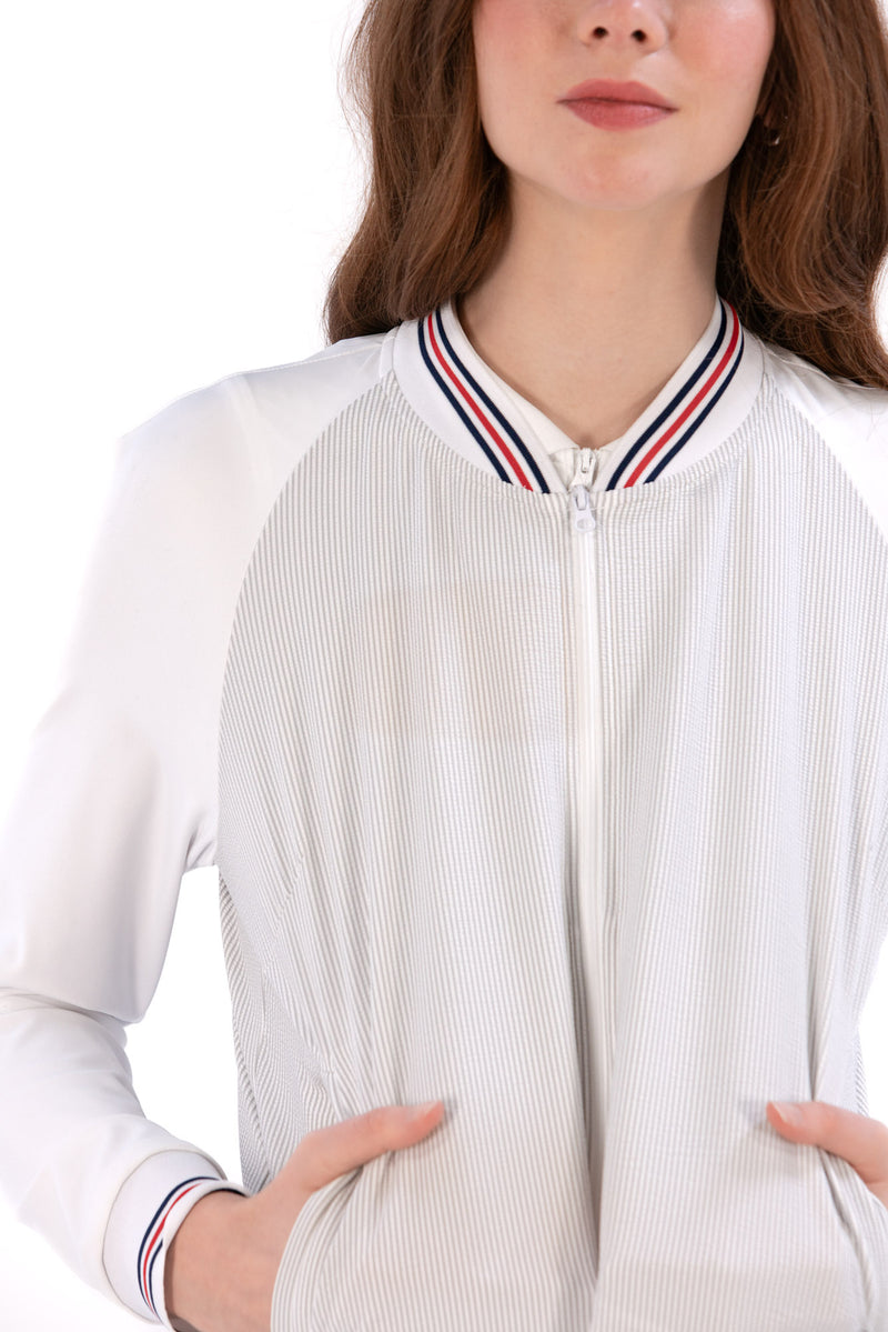 Woman wearing a Grey seersucker jacket with red accents on a white background