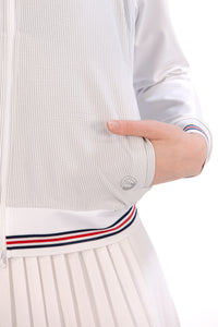 Woman wearing a Grey seersucker jacket with red accents on a white background