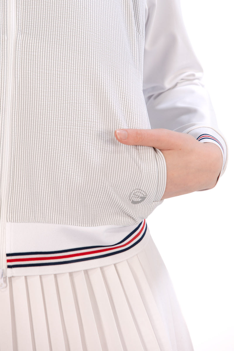 Woman wearing a Grey seersucker jacket with red accents on a white background