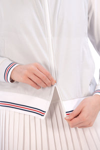 Woman wearing a Grey seersucker jacket with red accents on a white background