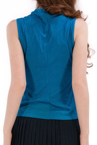 Woman wearing a Blue Opal sleeveless top and navy pleated skirt on a white background