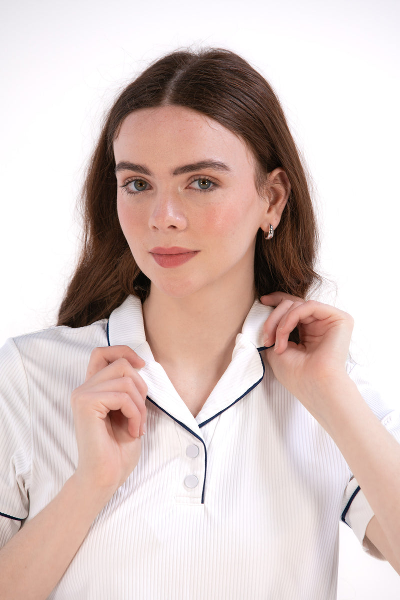 Woman wearing a white/navy top and navy skirt on a white background