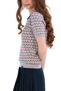 Woman wearing a Grey/Navy/Red patterned shirt, white shorts, and black socks on a white background