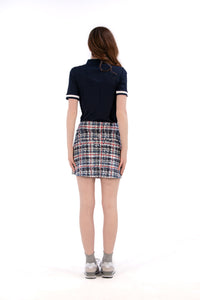 Woman wearing a navy polo shirt and plaid skirt on a white background Regular 15.5"
