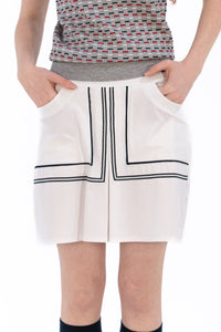 Woman in Tall 17" white skirt and knit polo.