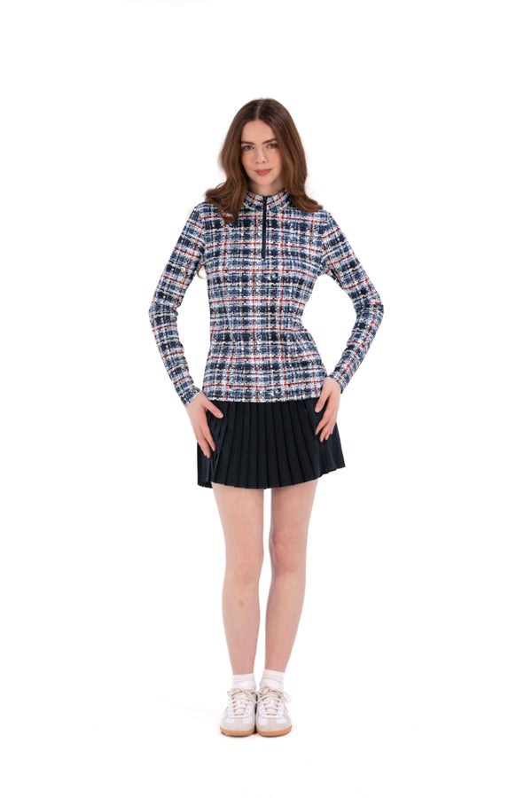 Woman wearing a Red White Blue Plaid shirt and navy pleated skirt on a white background