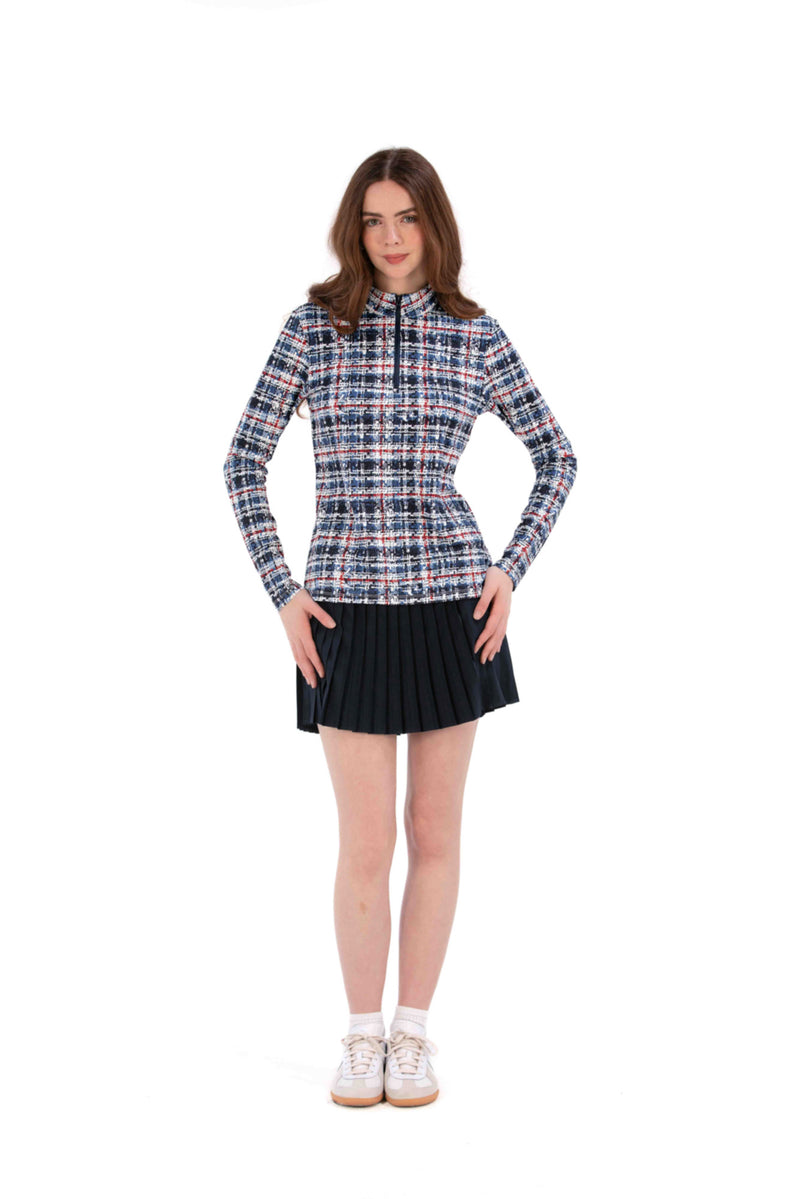 Woman wearing a Red White Blue Plaid shirt and navy pleated skirt on a white background