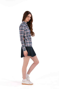 Woman wearing a Red White Blue Plaid shirt and navy pleated skirt on a white background