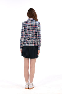 Woman wearing a Red White Blue Plaid shirt and navy pleated skirt on a white background