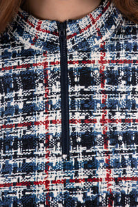 Woman wearing a Red White Blue Plaid shirt and navy pleated skirt on a white background