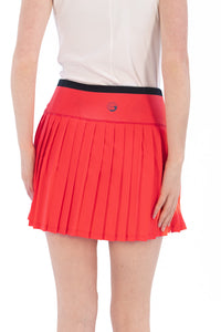 Coral pleated skirt worn by a person on a white background