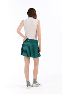 Woman wearing a white sleeveless top and Deep Jade pleated skirt on a white background