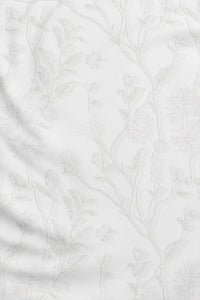 Woman wearing a White Textured Floral long-sleeve sun blocking top with a zipper, standing against a white background.